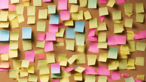 Image of a cork board full of post-it notes.